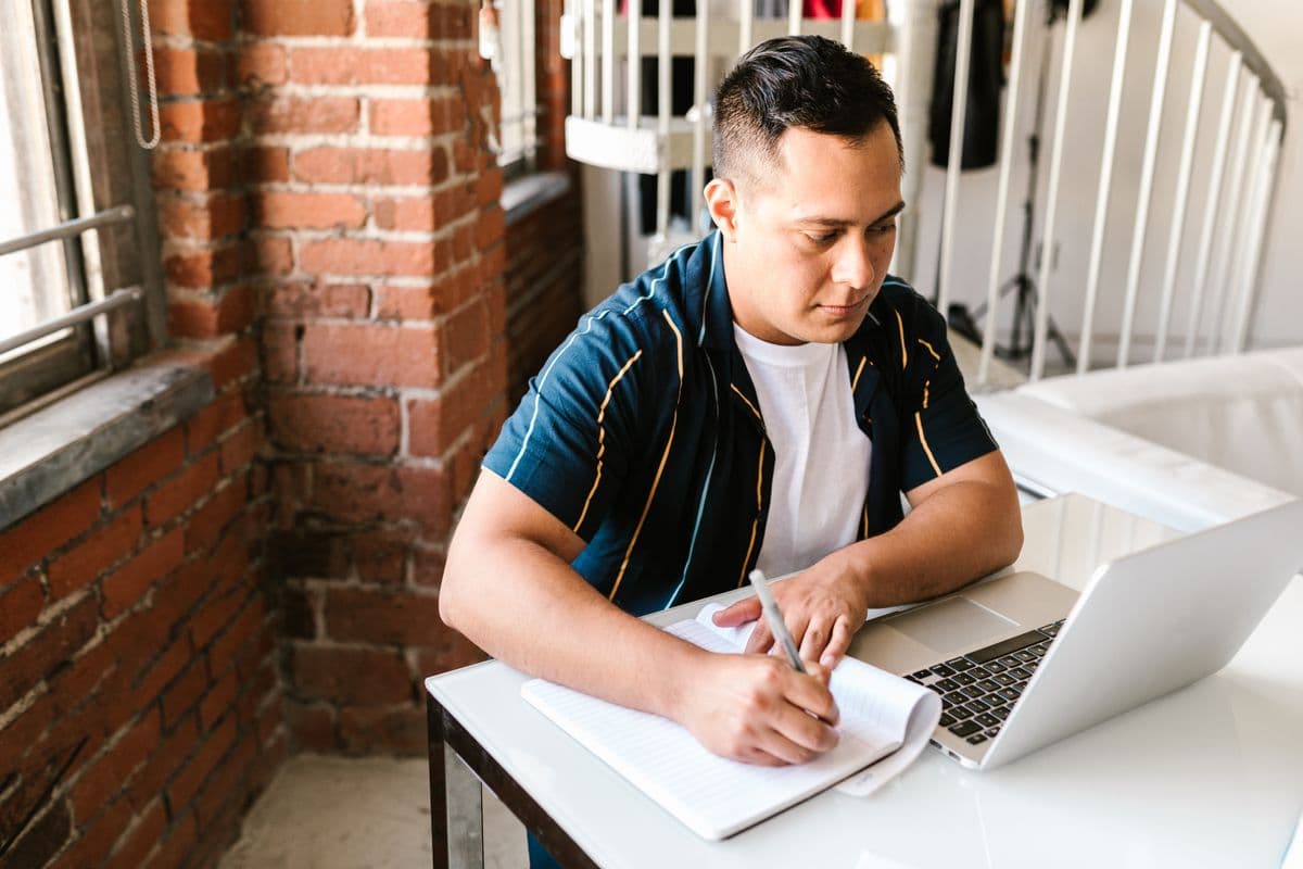 Personne concentrée, étudiant sur son ordinateur portable à la maison