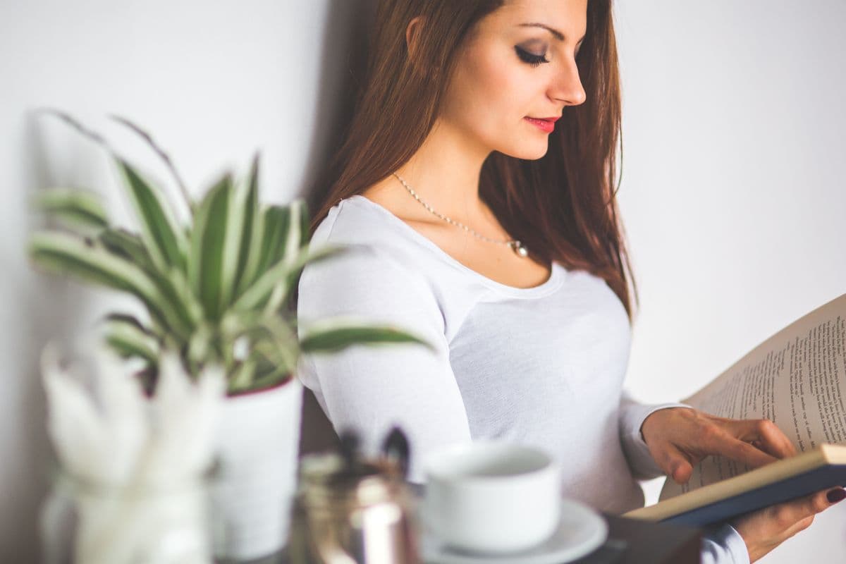 Personne savourant un moment de lecture tranquille chez elle